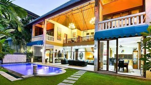 A two-story house with a swimming pool, a balcony, and a well-maintained lawn. - Bali Mystique Apartment (Keroboken Kelod)