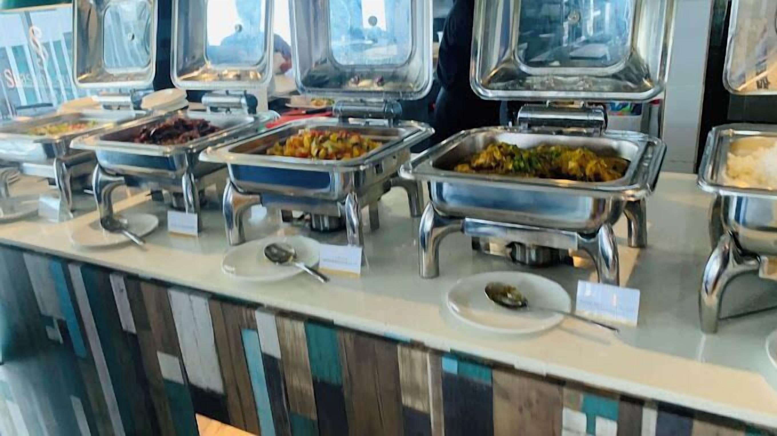 A buffet with various food items in metal serving containers.