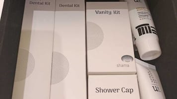A drawer containing a dental kit, a vanity kit, and a shower cap.