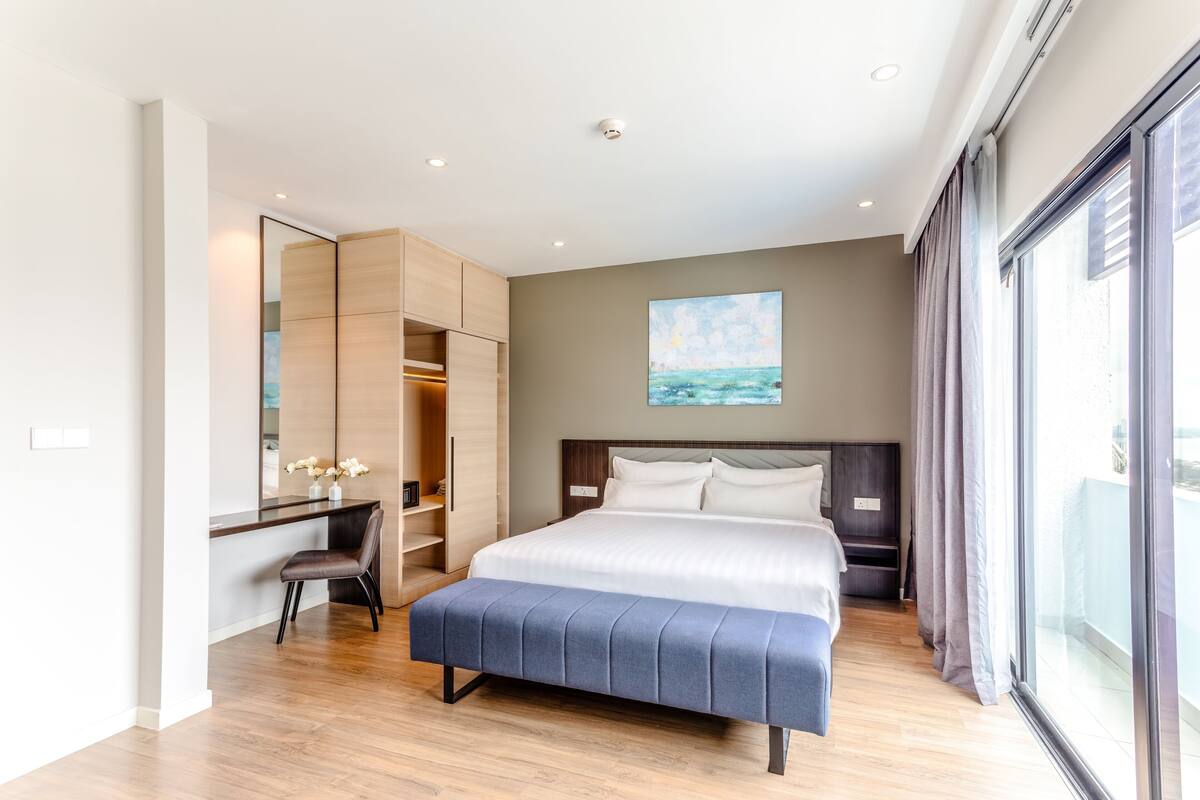 Ein modernes Hotelzimmer mit einem großen Bett, einem Schreibtisch und einem Kleiderschrank.