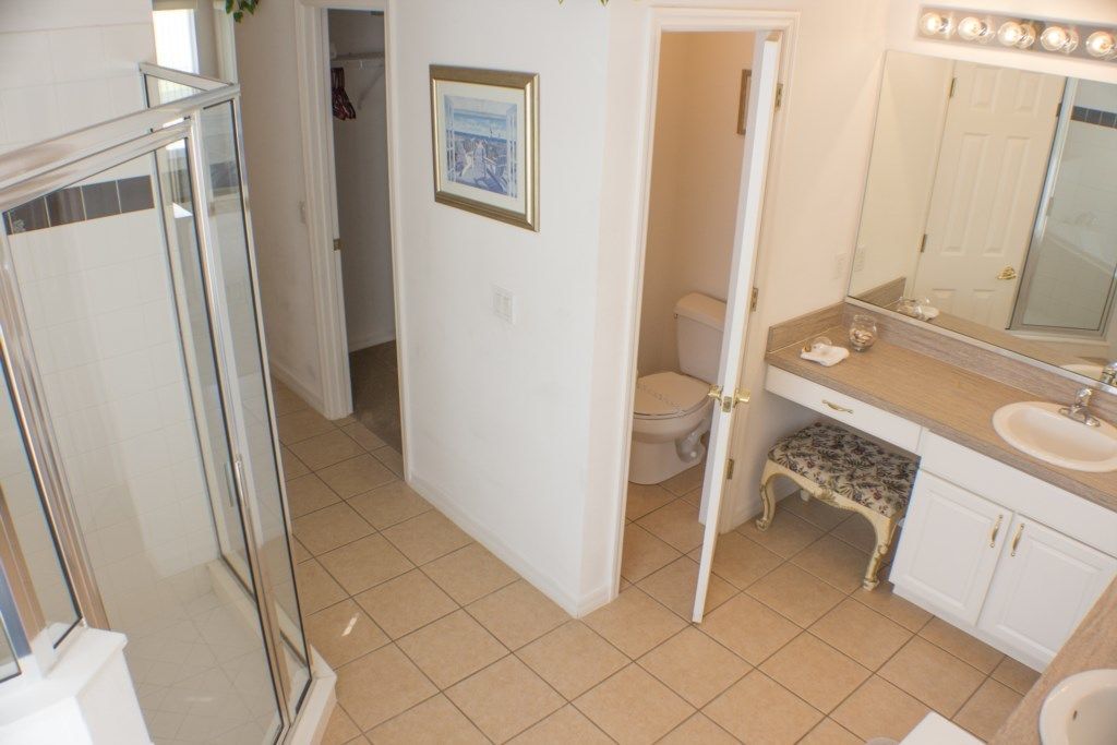 A bathroom with a shower, toilet, and vanity with a mirror.