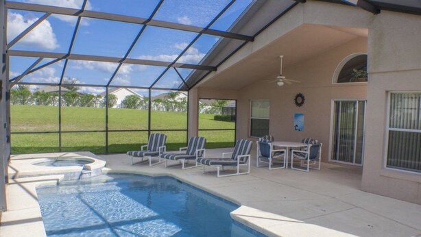 An indoor swimming pool with lounge chairs and a hot tub, surrounded by a covered patio area. - Ip60460 - Highgate at Legacy Park - 4 Bed 3 Baths Villa (Davenport)