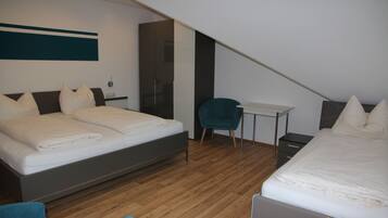 A modern bedroom with a large bed, a desk, and a chair.
