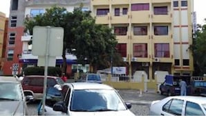 A multi-story building with a mix of residential and commercial spaces, featuring balconies and windows. - Hotel América (Praia)