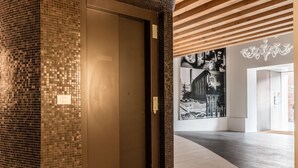 Un interior moderno con una pared de mosaicos, techo de madera y un gran mural en blanco y negro.