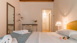 Una habitación de hotel con una cama, un escritorio, un espejo y una lámpara.