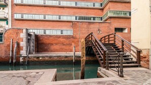 Un edificio de ladrillo con una escalera que desciende hacia un canal.