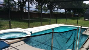 A swimming pool with a safety fence, surrounded by a grassy yard and trees. - Ahr237 - Hamlets at West Haven - 4 Bed 3 Baths Villa (Davenport)