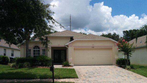 A residential house with a garage, a driveway, and a well-maintained lawn. - Ahr237 - Hamlets at West Haven - 4 Bed 3 Baths Villa (Davenport)