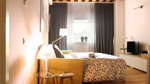 A bedroom with a bed, a bedside table, a lamp, a TV, and a window with curtains. - MAZZONI 15 MODERN FLAT BY VENICE TRAIN STATION (Venezia)