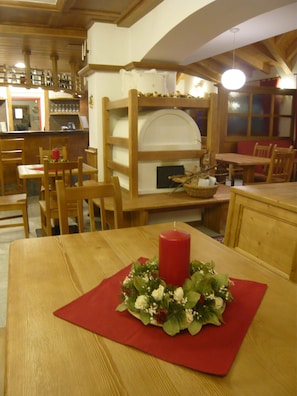 A cozy restaurant with wooden furniture, a red candle centerpiece, and a rustic interior.