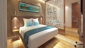 A modern bedroom with a large bed, a decorative wall panel, and a painting above the bed. - Effotel By Sayaji Vadodara (Vadodara)