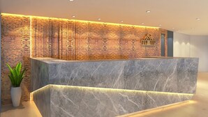 A reception desk with a marble top and a textured wall behind it. - Effotel By Sayaji Vadodara (Vadodara)