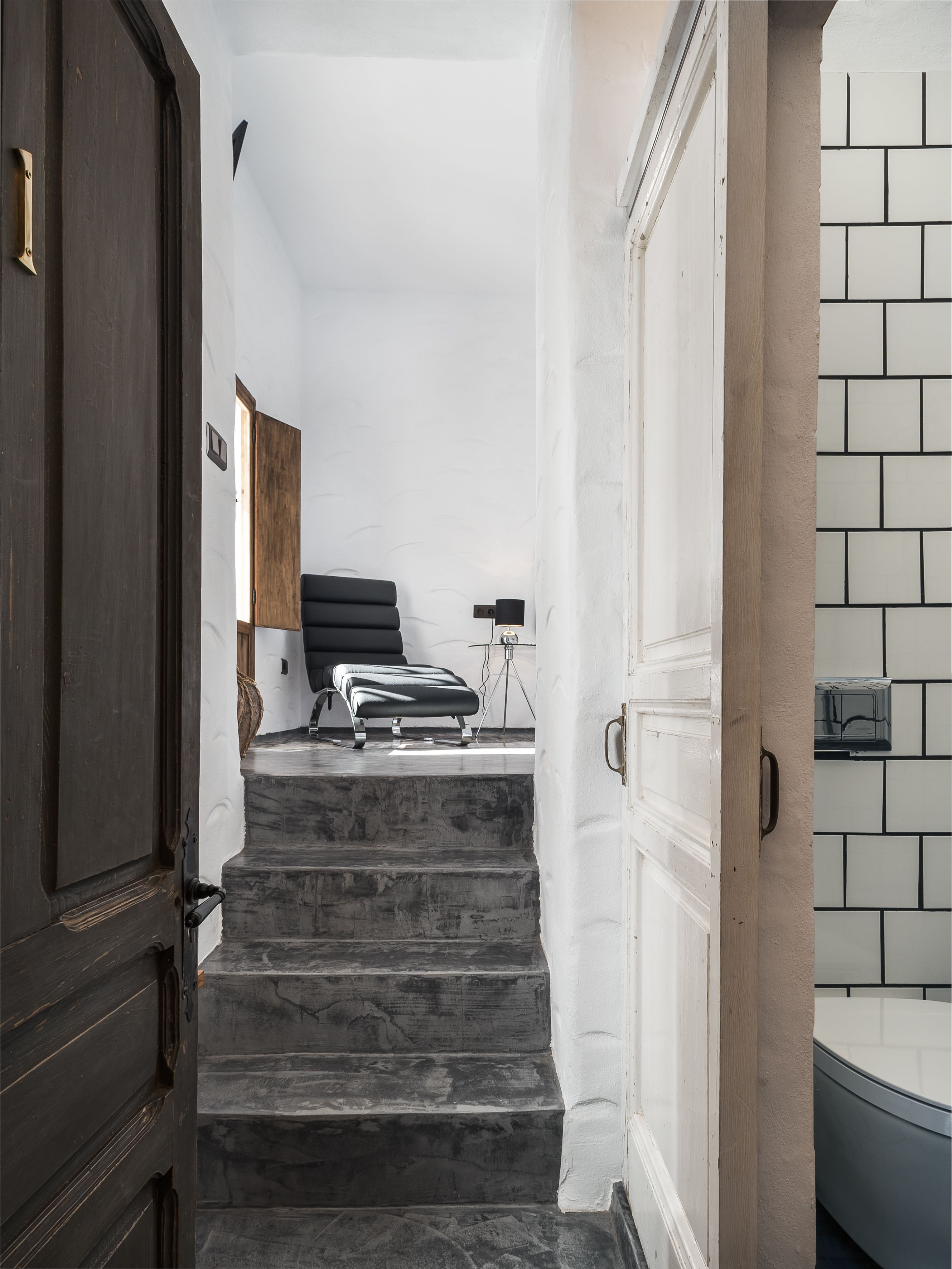 A staircase leading to a room with a bed, a desk, and a lamp.