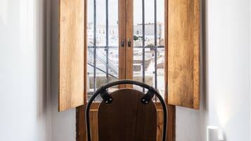 Una habitación con una puerta de madera, una silla y un bolso de cuero marrón.
