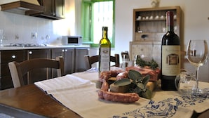 Une table à manger avec une bouteille de vin, un verre et de la viande crue.