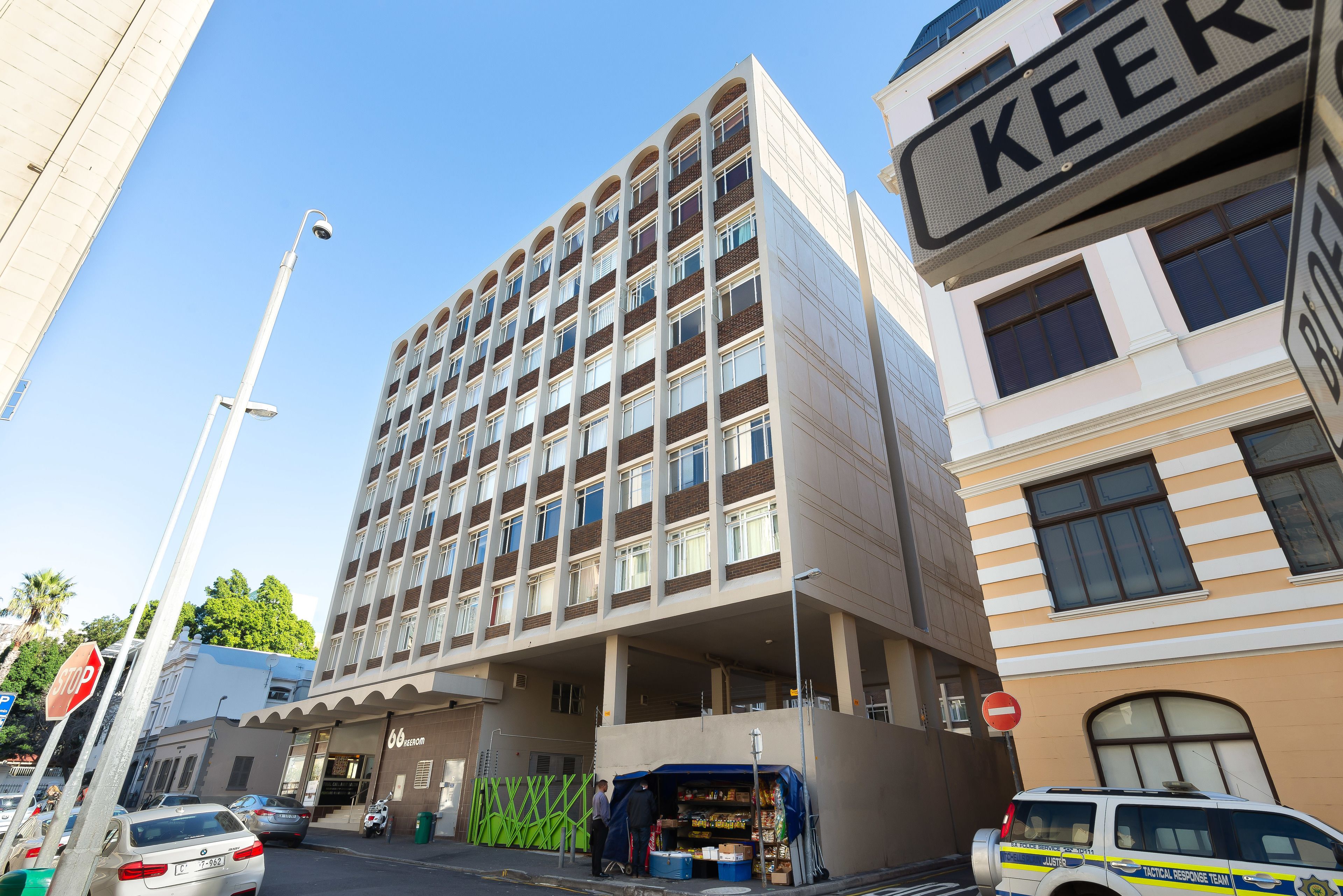 A multi-story hotel with a modern architectural design, featuring a prominent 'KEER' sign, a covered entrance, and a visible outdoor seating area. - 66 Keerom 715 (Cape Town)