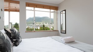 A bedroom with a large window, a bed, and a mirror. - 66 Keerom 715 (Cape Town)