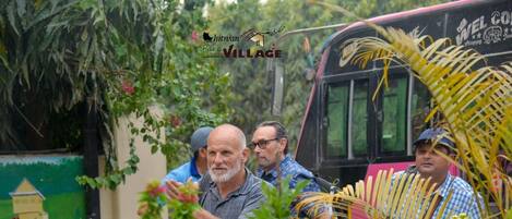 A group of people near a bus with a sign that reads "Chintan Park Village".