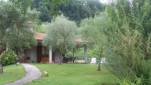 Una casa con jardín, un camino de piedra y un pequeño arroyo.