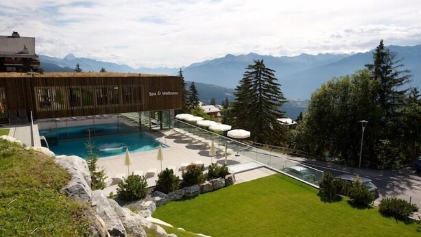 Un hôtel moderne doté d’une piscine, d’un espace extérieur aménag é et offrant une vue sur les montagnes.