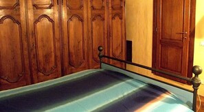 A room with a bed, wooden wardrobe, and a door. - Guelfa Patio apartment (Florence)