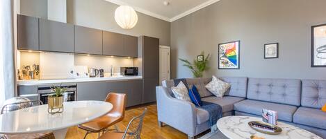 A modern living space with a dining area, kitchen, and seating area.