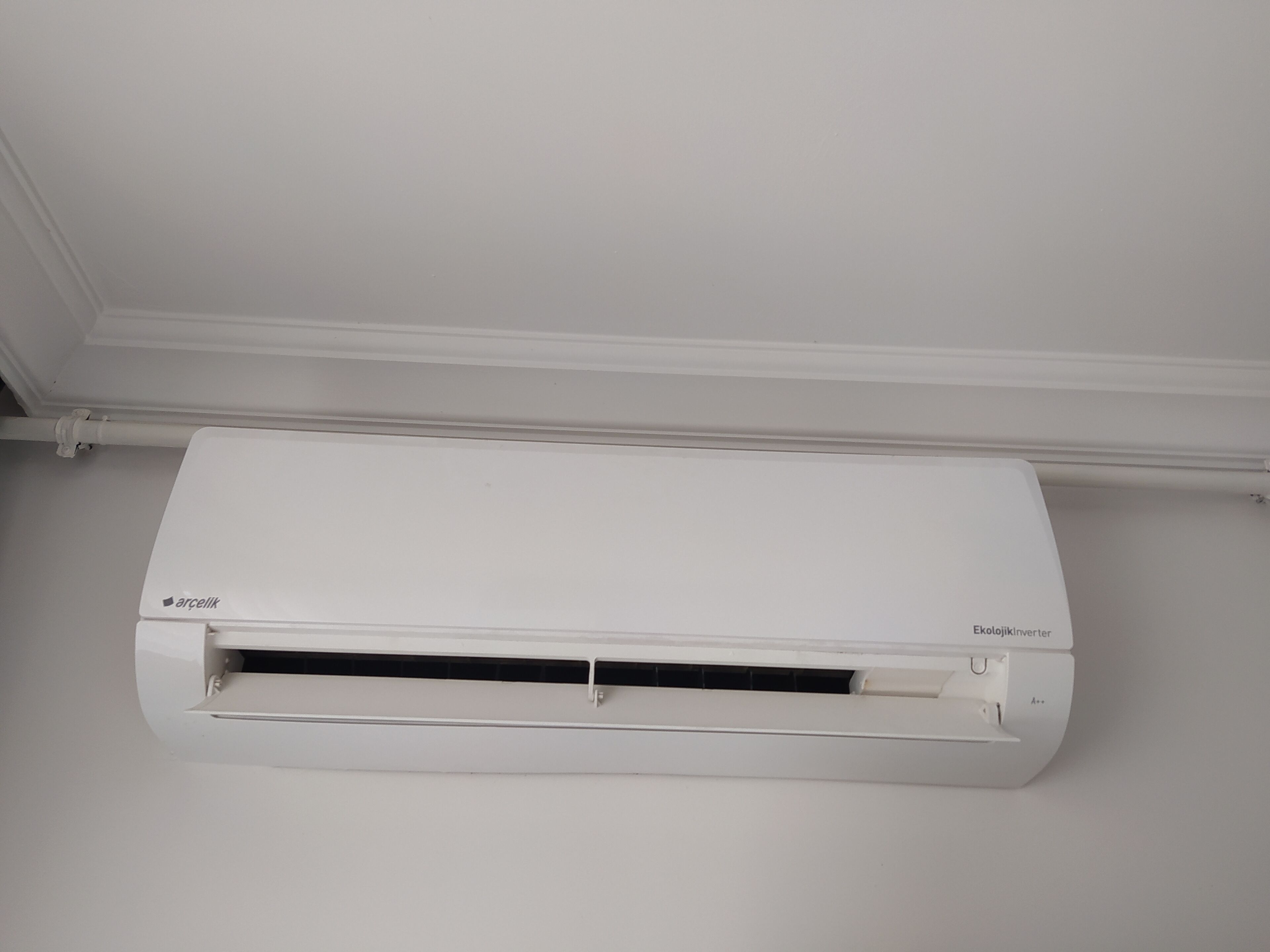 A white air conditioning unit mounted on a wall.