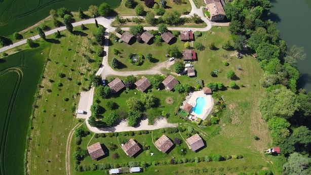 Vue aérienne d’un quartier résidentiel avec des maisons, une piscine et une rivière.