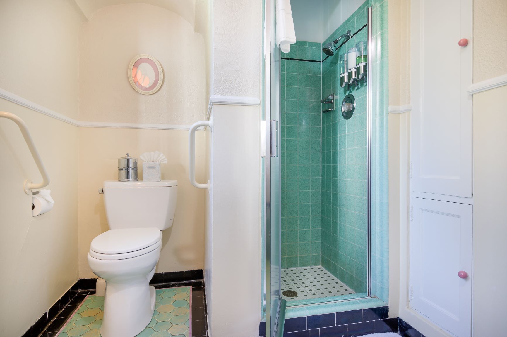 Une salle de bain comprenant des toilettes, une douche avec une porte en verre et un lavabo.