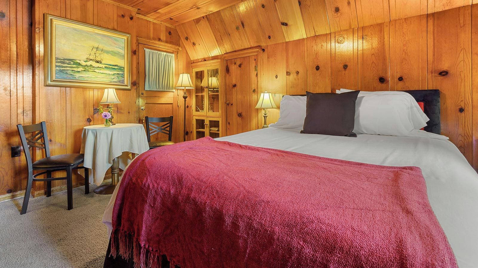 Una habitación con paneles de madera, una cama, un escritorio y una silla.