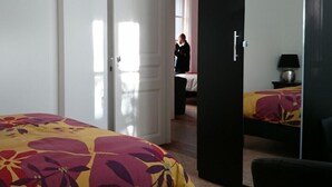 Une chambre d’hôtel avec un lit, une armoire et un miroir.