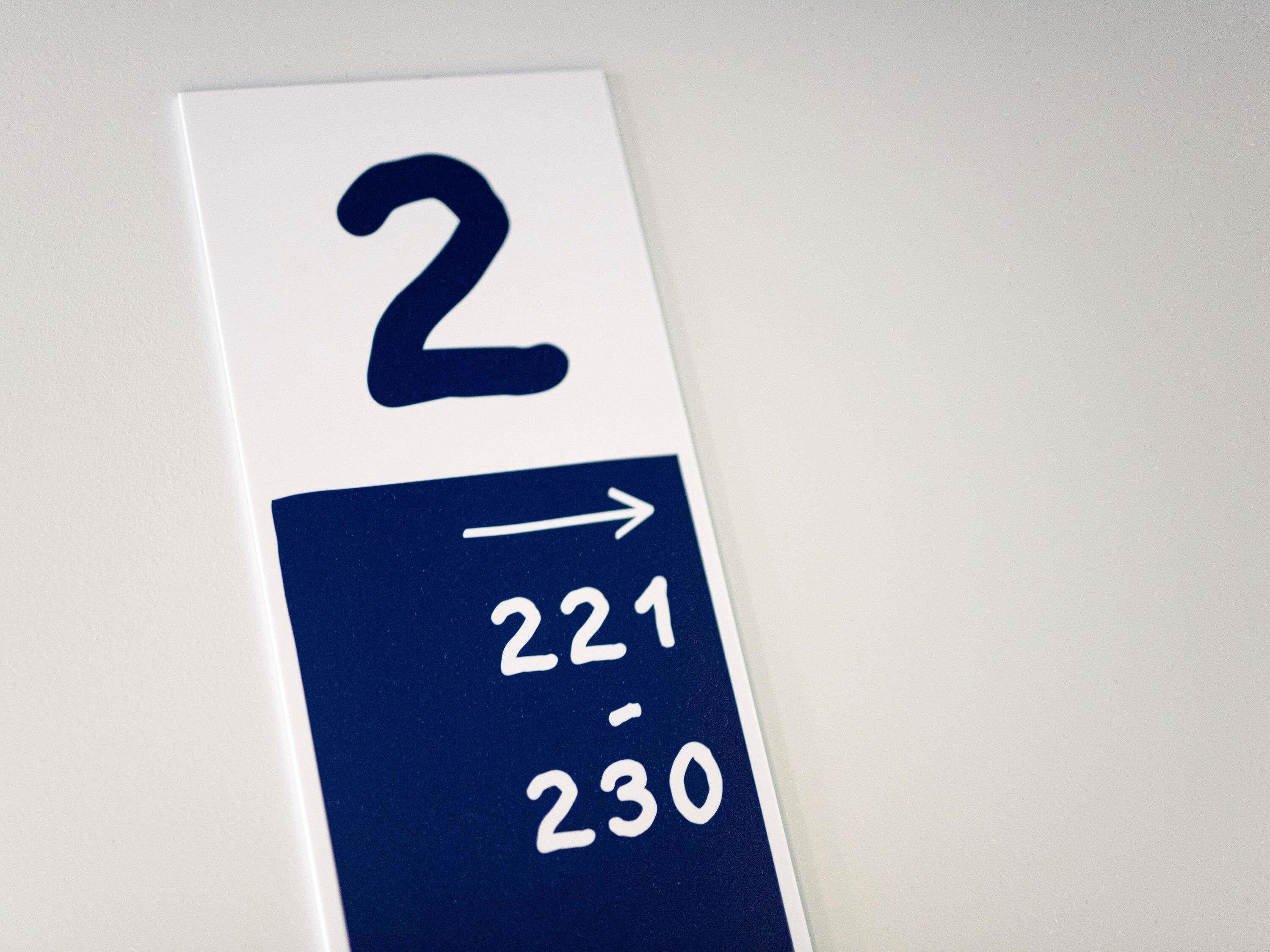 Un panneau indiquant le numéro 2 et une flèche pointant vers la droite, ce qui signale une direction ou un lieu.
