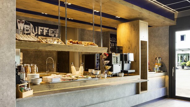 A modern breakfast bar with a variety of food items and a coffee machine.