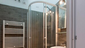 Une salle de bain moderne avec une douche à parois de verre, un bidet et un lavabo.