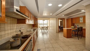 A modern kitchen with a central island, built-in cabinets, and a dining area with a table and chairs.