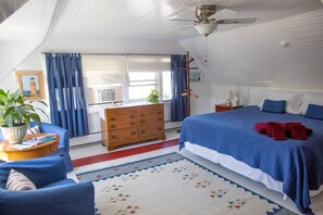 A bedroom with a large bed, a dresser, a desk, and a ceiling fan. - The Red Door B&B (Lee)