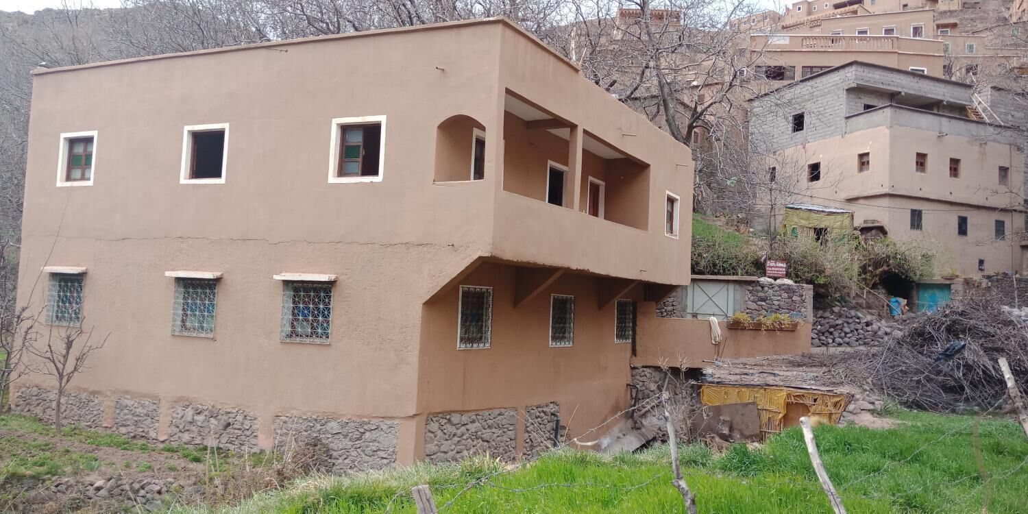 Ein mehrgeschossiges Gebäude mit einer flachen Fassade, zahlreichen Fenstern und einem Balkon.