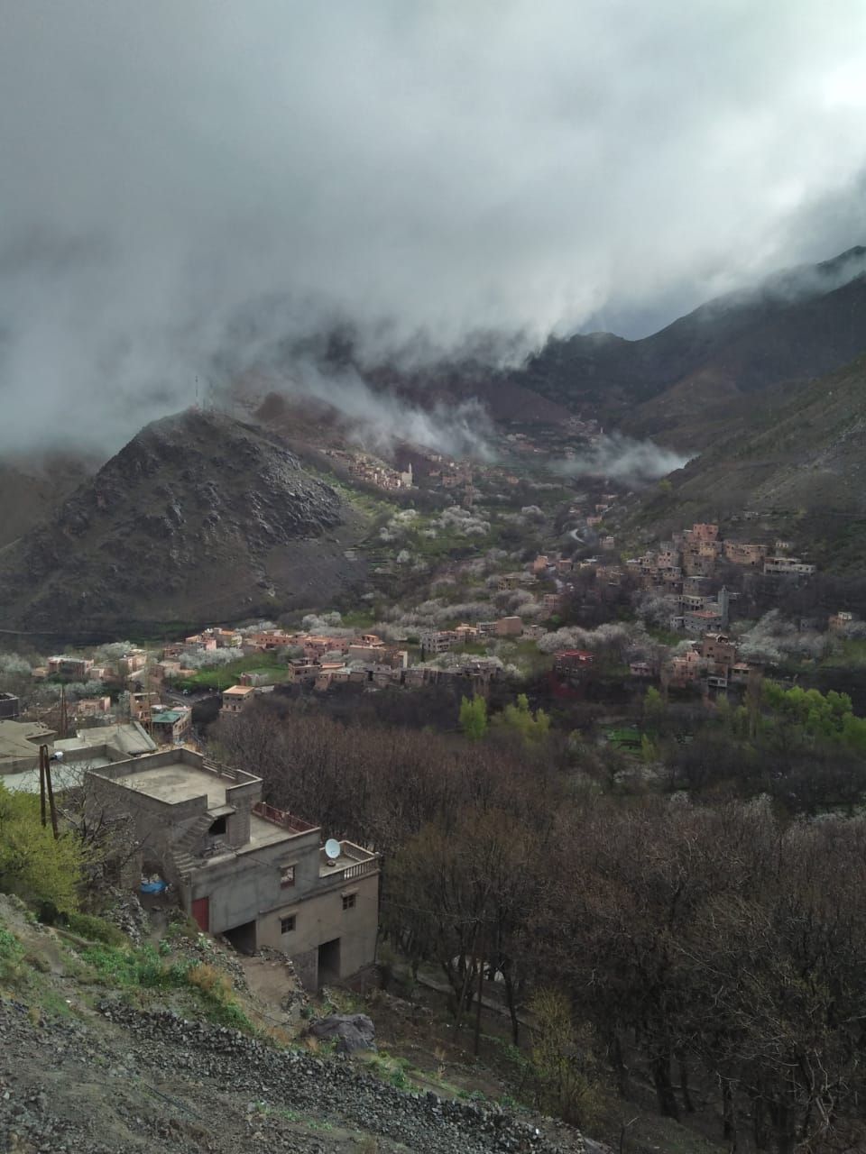 A mountainous village with traditional buildings and a rugged landscape.