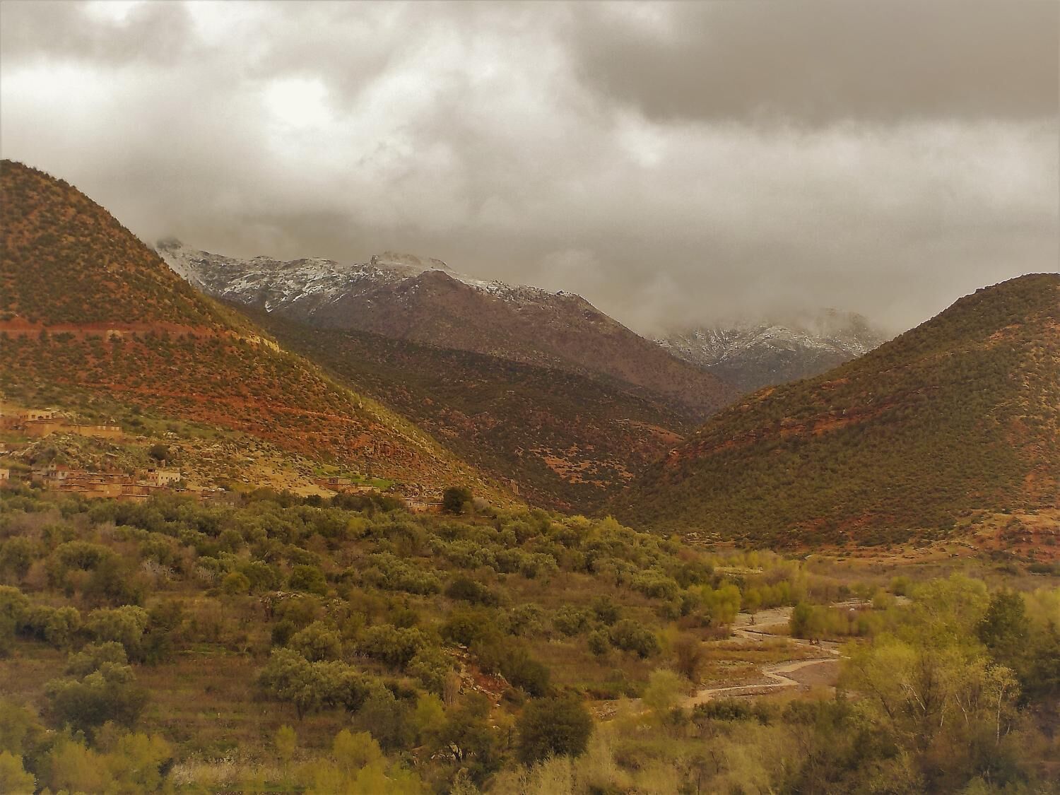 A mountainous landscape with a valley and a river.