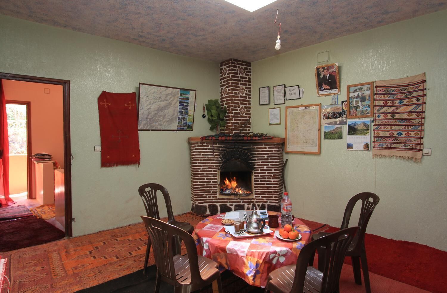 A dining area with a brick fireplace, a table set for two, and various wall decorations.