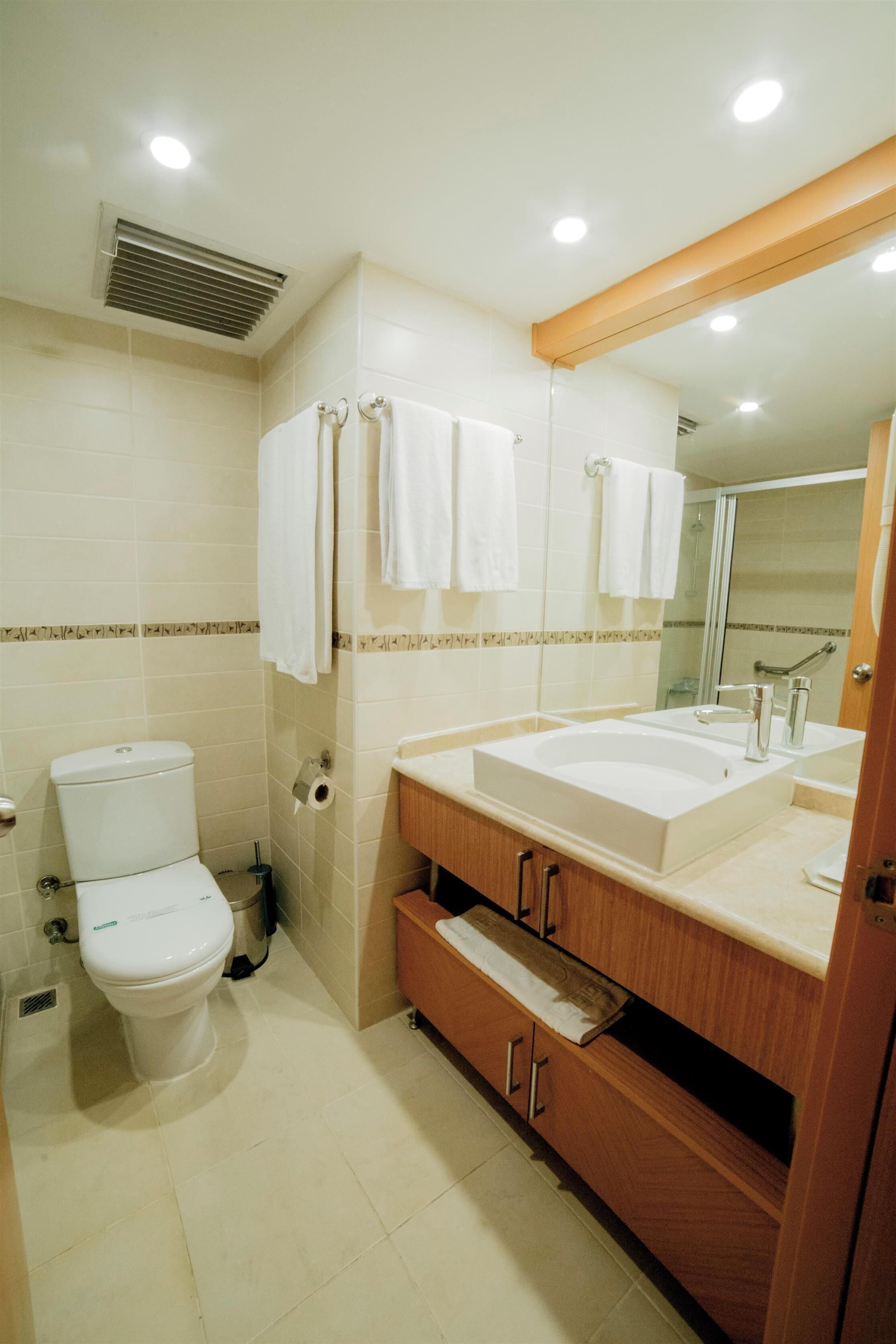 A modern bathroom with a toilet, sink, and shower.