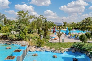 A pool area with multiple swimming pools, lounge chairs, and umbrellas.