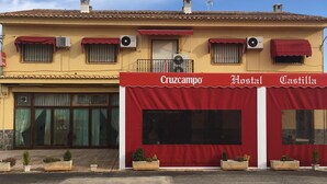 A building with a red awning displaying the name "Cruzcampo Hostal Castilla". - Hostal Castilla (Torrenueva)