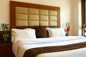 A neatly made bed with a wooden headboard and white bedding.