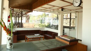 Una sala de estar moderna con techo de madera, un sofá, una mesa de centro y un reloj.