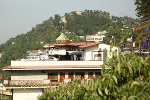 A hotel with a red roof, a golden dome, and a sign for Hotel Devlok Premier. - Hotel Devlok Primal (Dehradun)