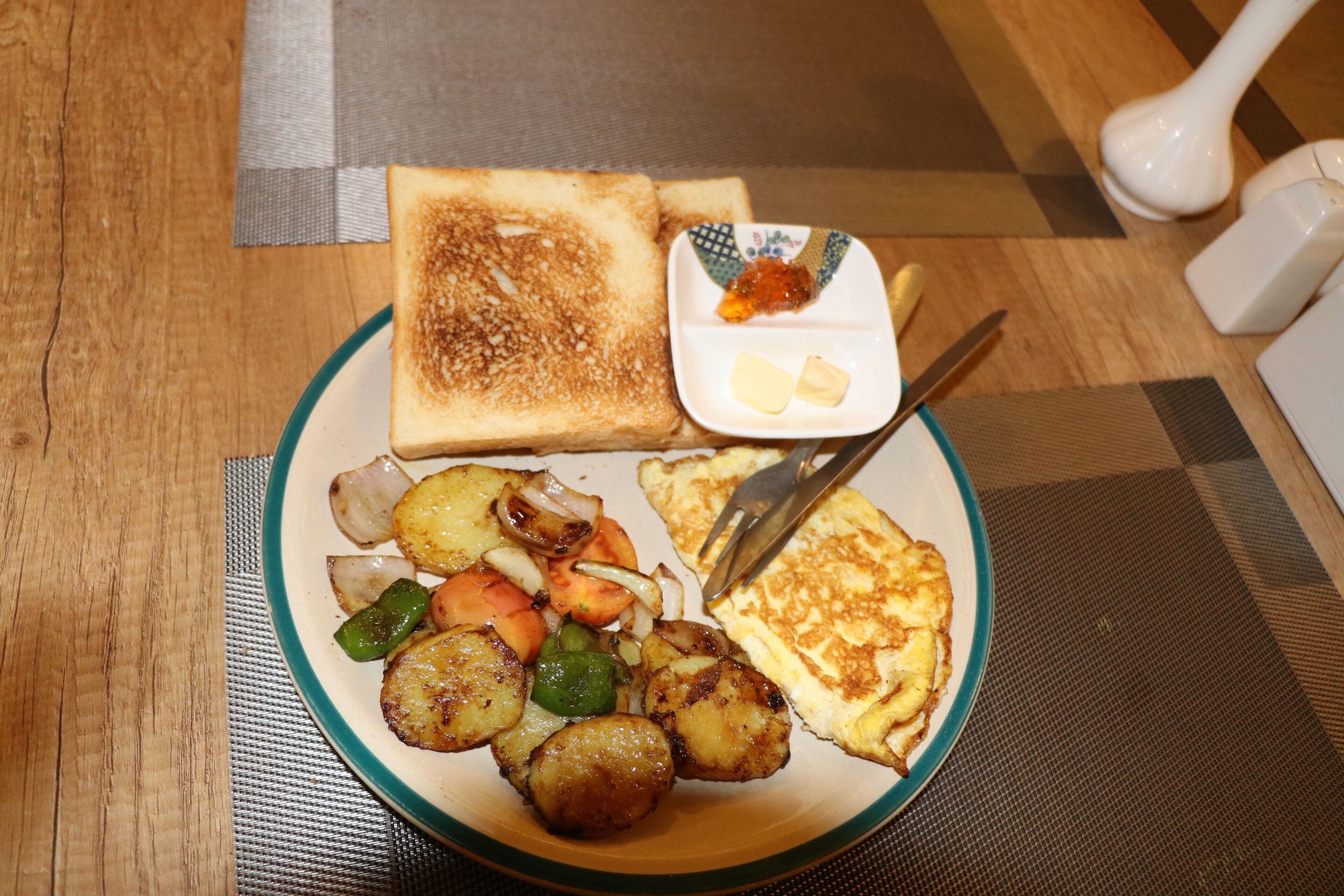 A plate with toast, scrambled eggs, and sautéed vegetables.