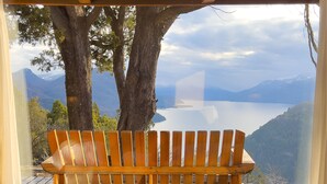 A wooden bench with a view of a lake and mountains. - Arrayan Lake View Mountain Lodge & Casa De Te Arrayan (San Martín de los Andes)