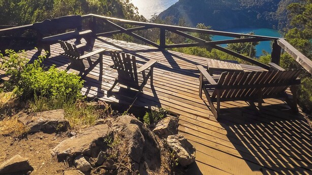 A wooden deck with chairs overlooking a lake and mountains. - Arrayan Lake View Mountain Lodge & Casa De Te Arrayan (San Martín de los Andes)